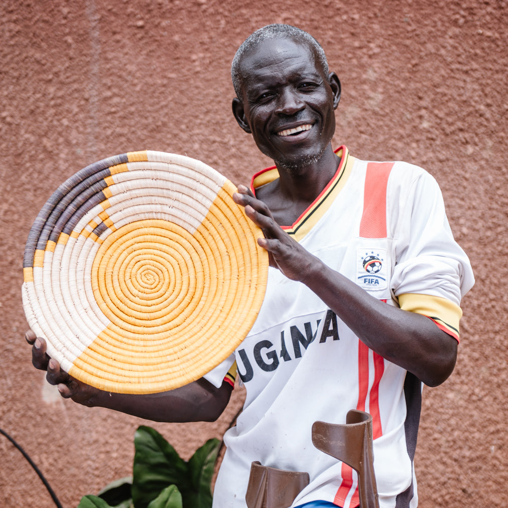 JustOne's yellow wall basket with grey and tan design, handwoven in Uganda