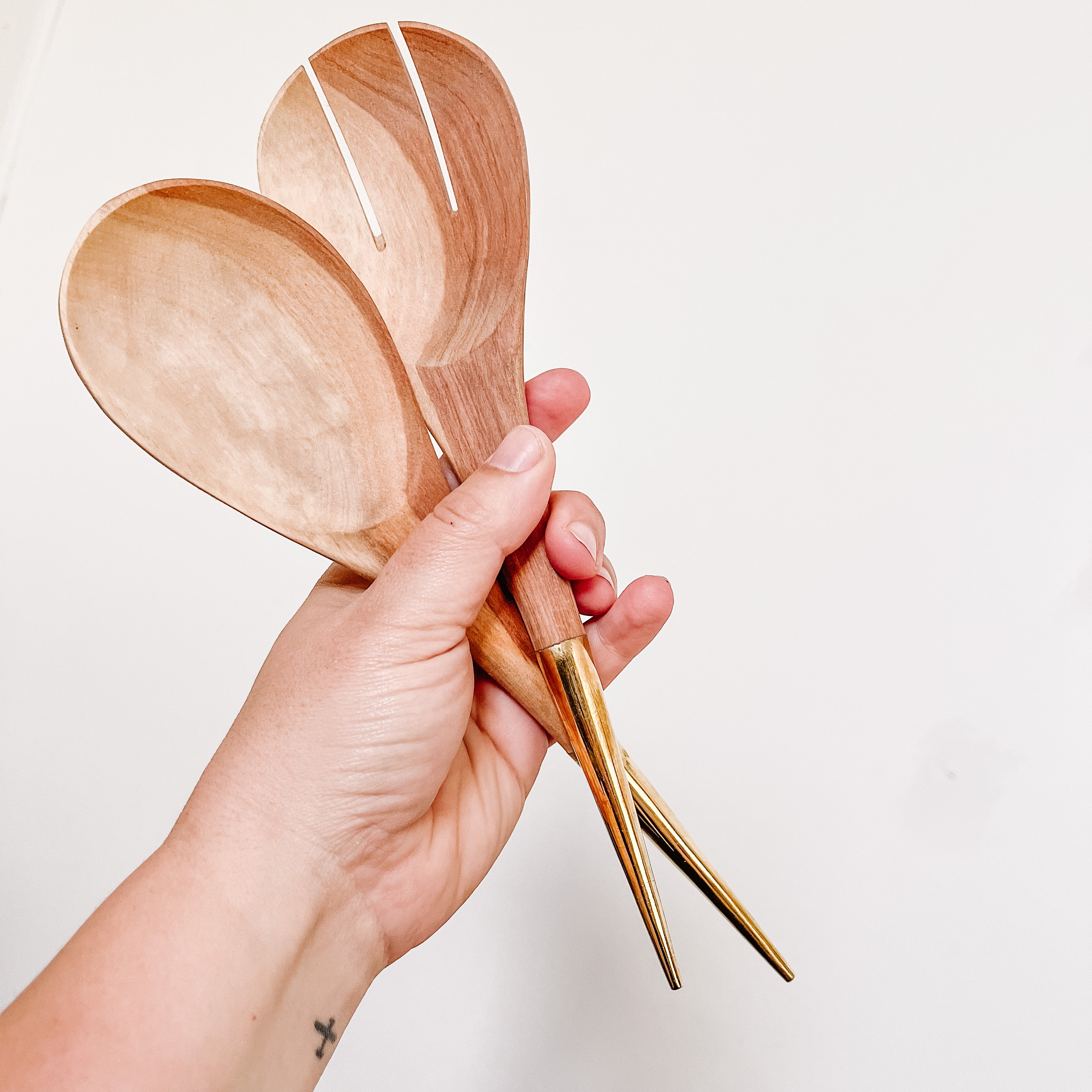 JustOne's handcrafted wooden salad spoons with a handle made of brass that comes to a point, made in Kenya