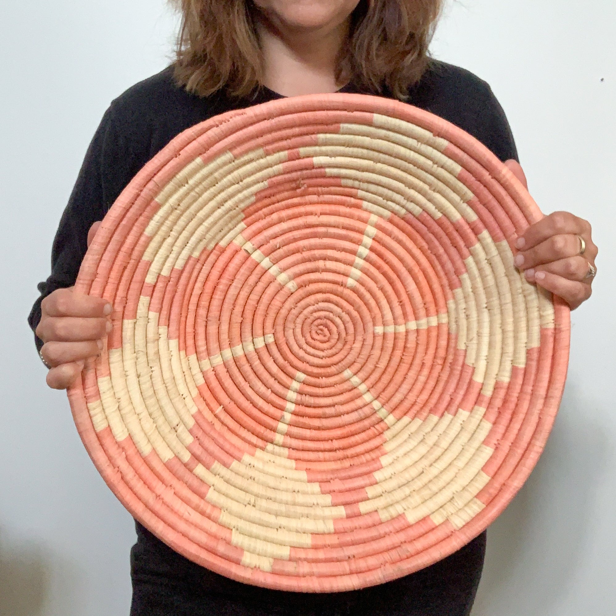 JustOne's pink wall basket with star design, handwoven in Uganda