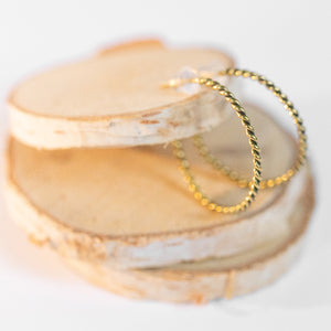 JustOne's brass hoops that has a twist design handcrafted in Kenya