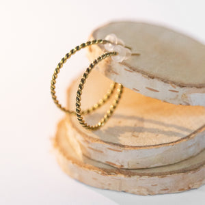 JustOne's brass hoops that has a twist design handcrafted in Kenya